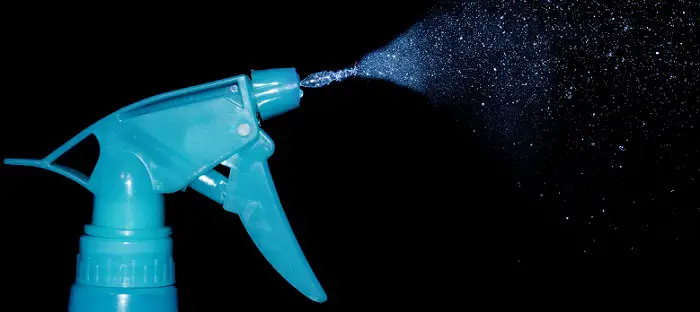 a blue spray bottle on a black background